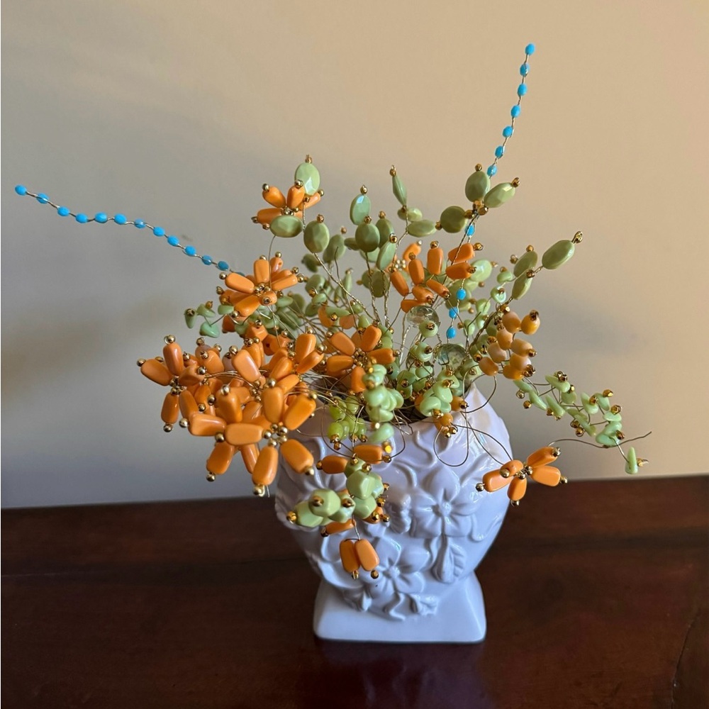 Artificial beaded flowers in white vintage vase